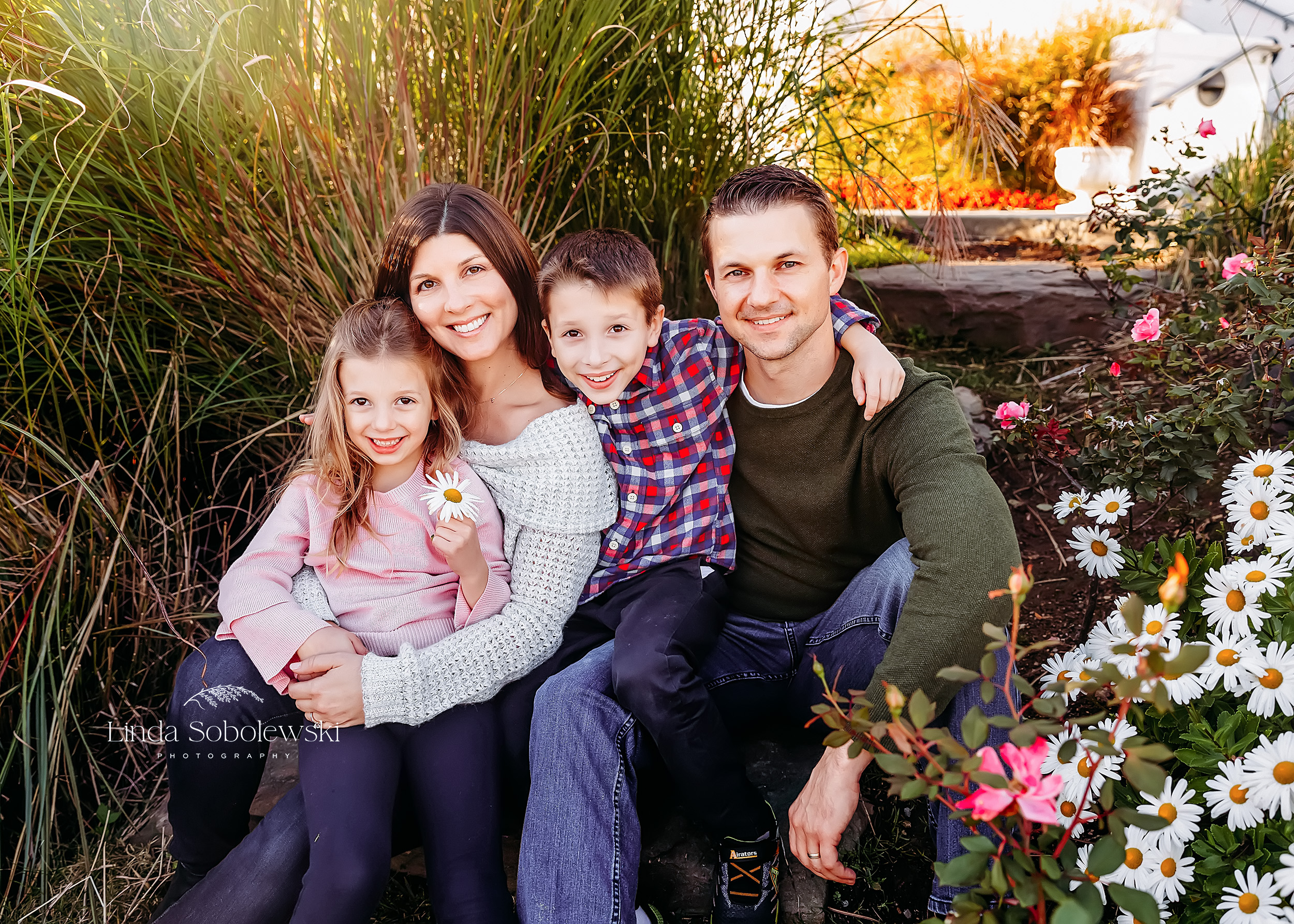 family of four sitting together is color coordinated outfits, What To Wear for your family photos. Connecticut's Best Family Photographer