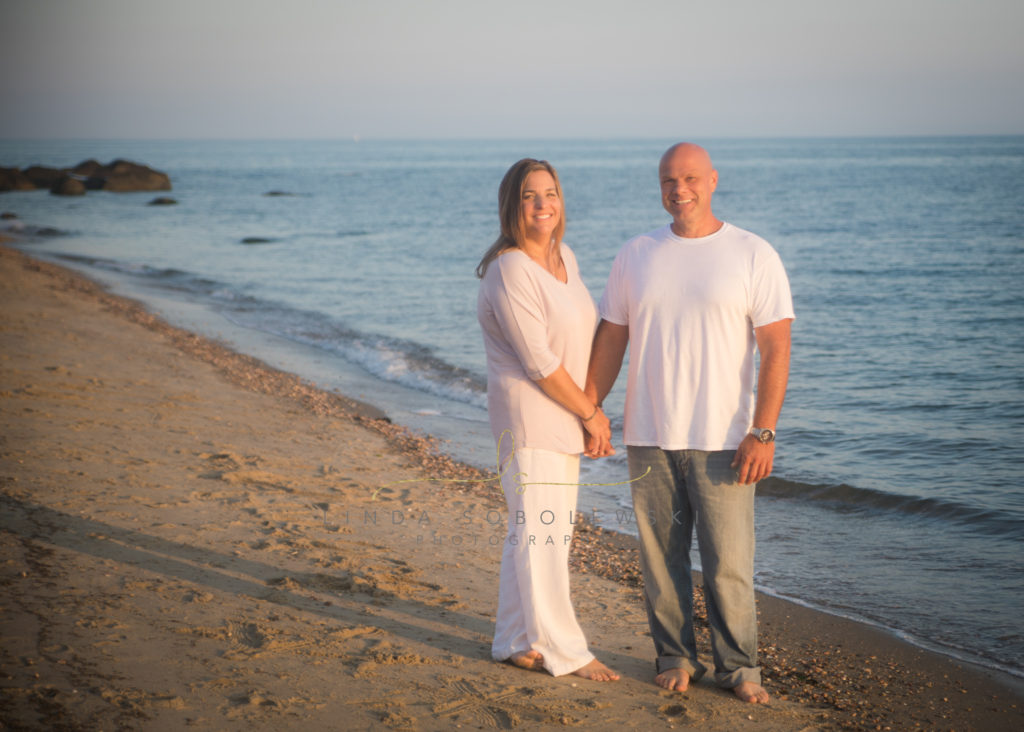 couple standing on the beach in the sunset, madison, ct photographer