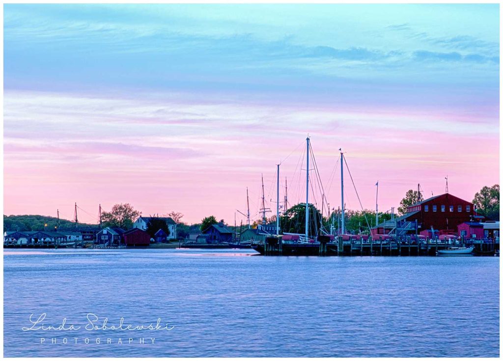 pink and blue skies with a boat in downtown essex, ct