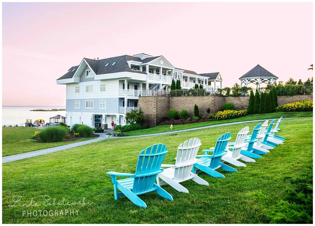 row of adirondack chairs on a lawn overlooking the ocean on the 4th of July weekend