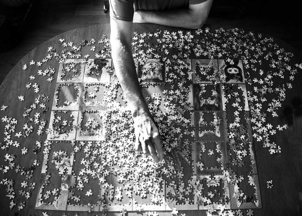 black and white image of a person doing a jigsaw puzzle, Westbrook CT photographer