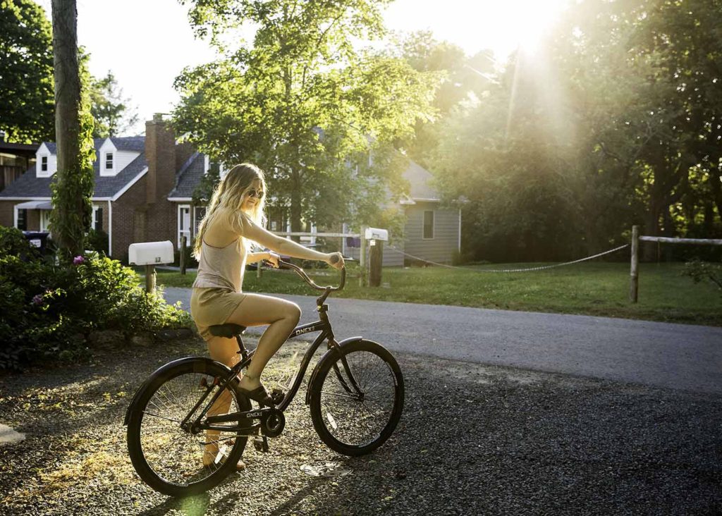 girl with blonde hair riding bike in the sunshine, Westbrook family photographer