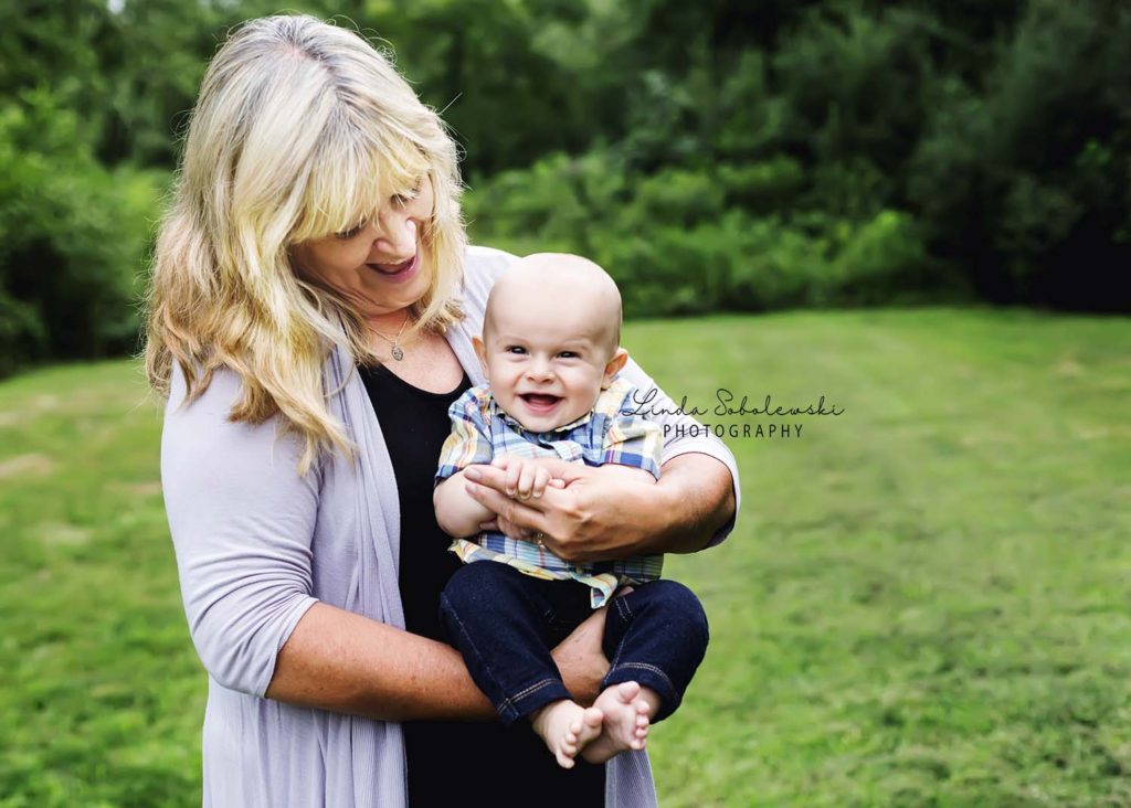 grandmother holding laughing baby boy