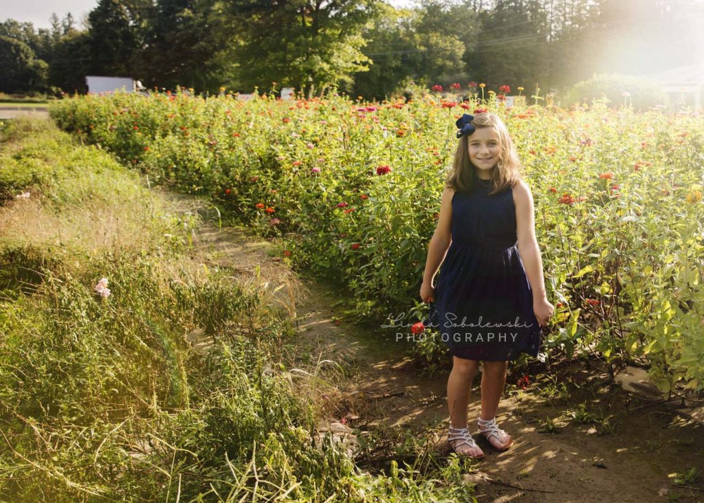 girl in blue dress twirling in field of flowers, Connecticut shoreline photographer