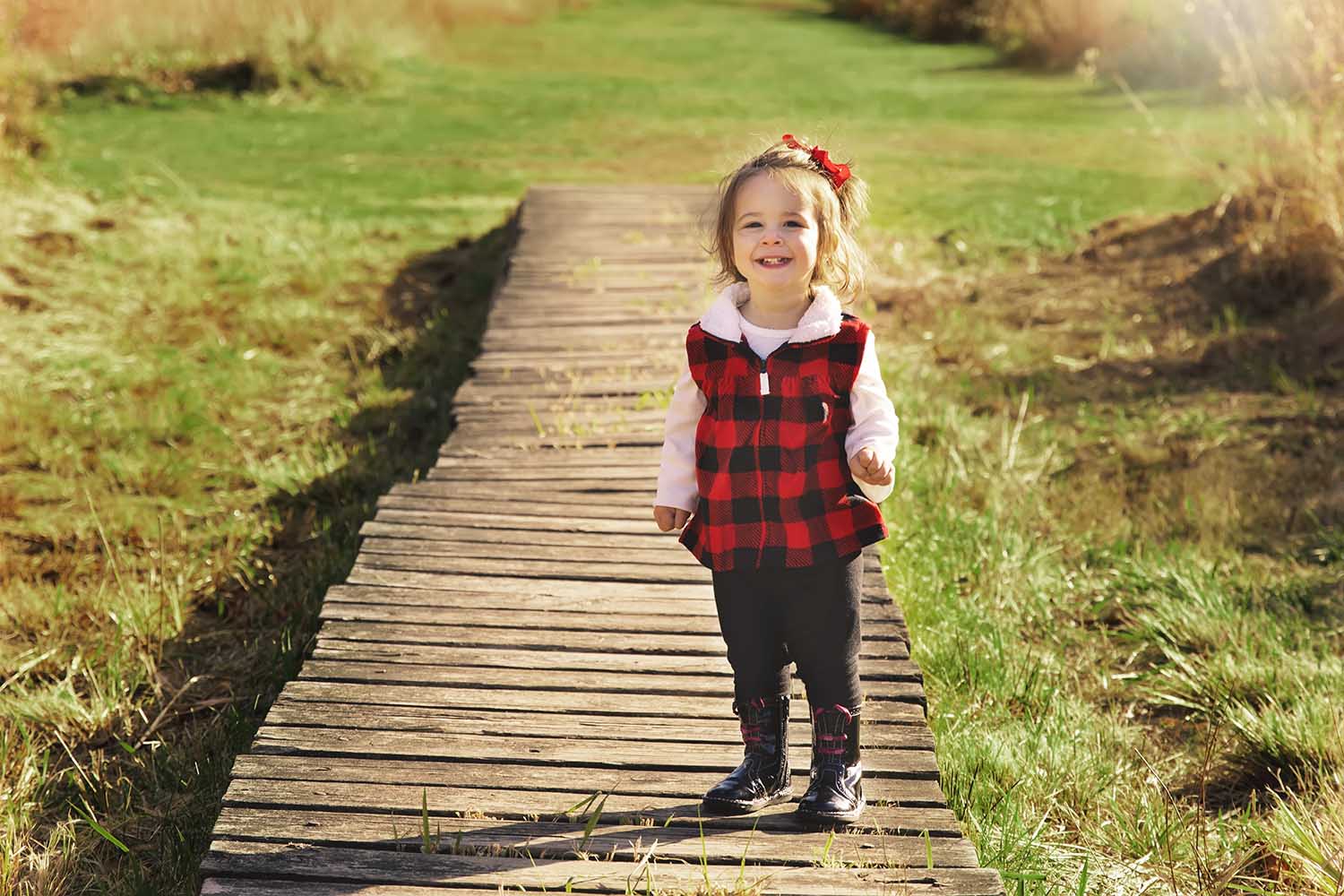 little girl in red vest standing on wooden platform, Bauer Park Photography
