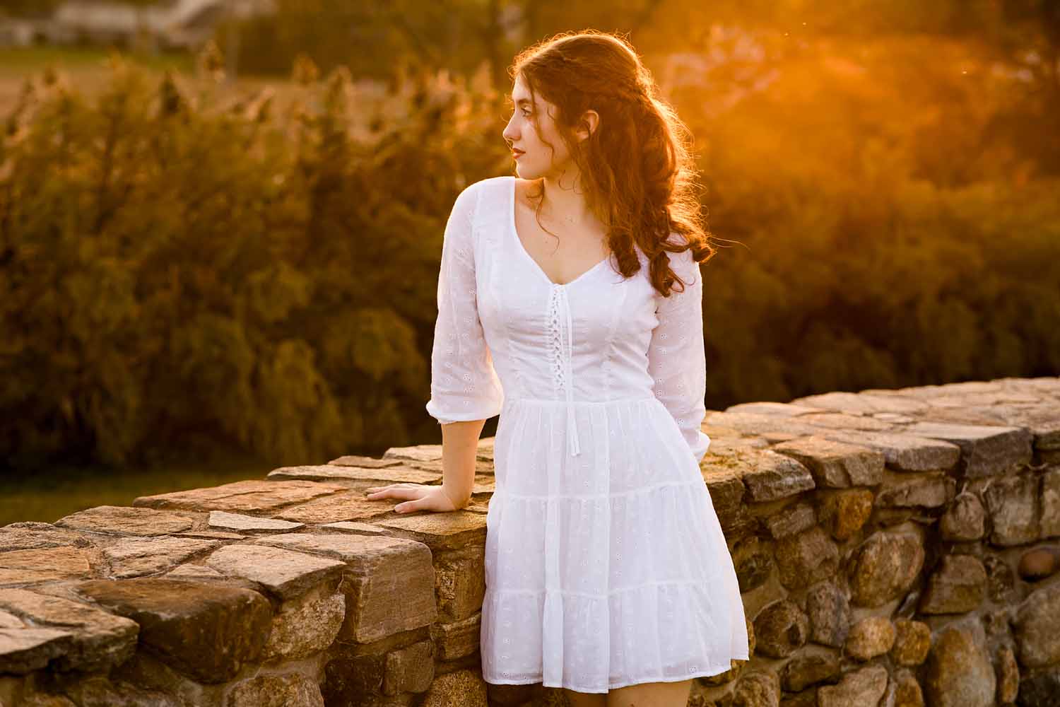 girl in white dress leaning against a wall during sunset, Old Saybrook High School Senior Photographer
