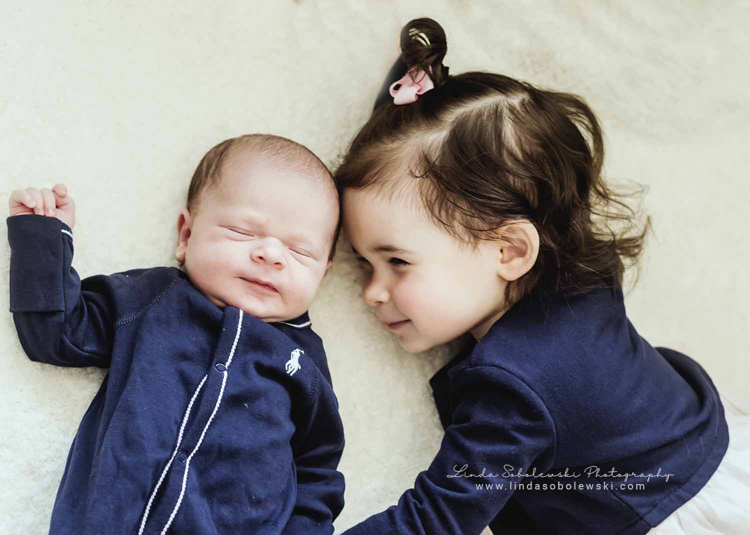 newborn baby and sister laying on a rug, Westbrook child photographer