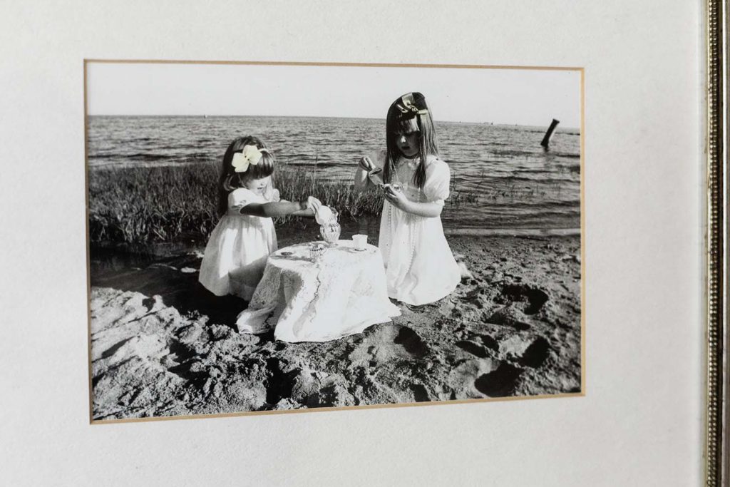 matted and framed photo of two little girls in white dresses having a tea party at the beach, why you should print your photos