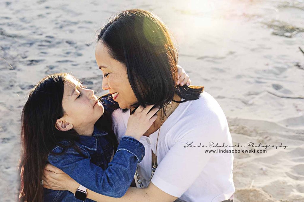 little girl giving her mom a kiss at the beach, old Saybrook ct family photographer