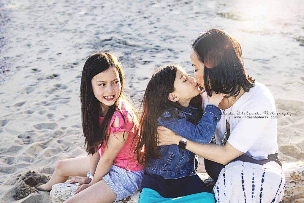 little girl giving her mom a kiss at the beach, family session, westbrook ct photographer