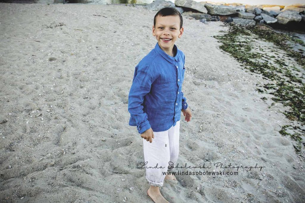 adorable little boy with Williams syndrome at the beach, westbrook ct photographer
