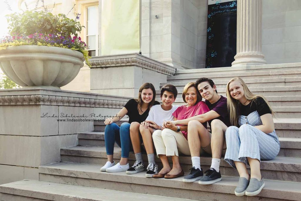 grandmother and her four grandchildren sitting on the steps of the library, extended family session, branford ct photographer