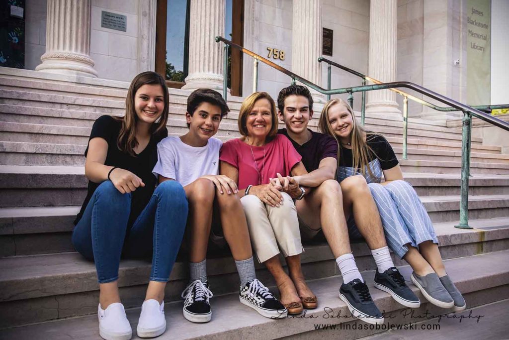 grandmother and her four grandchildren sitting on the steps at the Blackstone library, extended family session, branford ct photographer