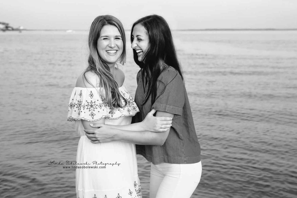 black and white image of two sisters laughing at the beach, westbrook ct family photographer