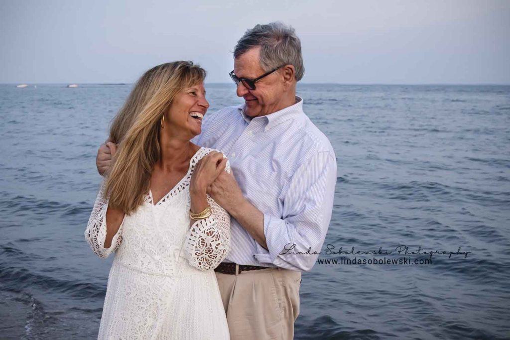husband and wife lovingly looking at each other, water's edge family photo session, westbrook ct photographer