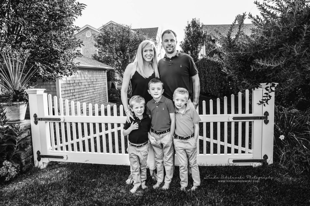 black and white image of family of five standing by a fence, cornfield point old Saybrook ct photographer