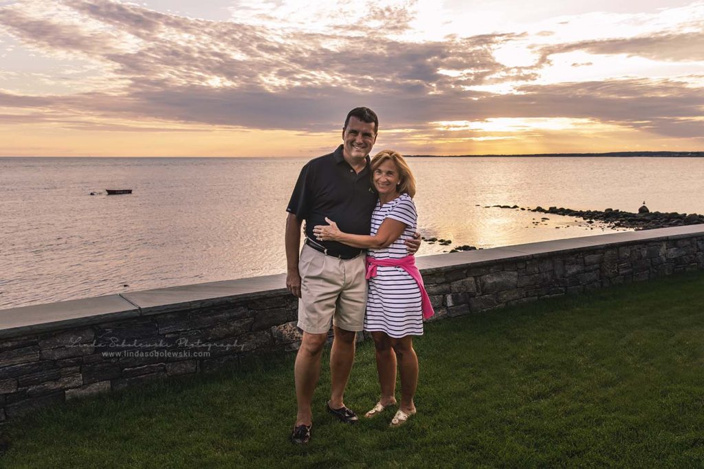 couple standing in their yard with a beautiful sunset, cornfield point in old Saybrook, Connecticut lifestyle photographer