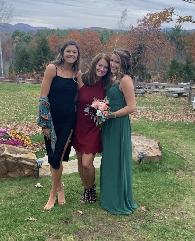 three woman dressed up with the fall foliage behind them