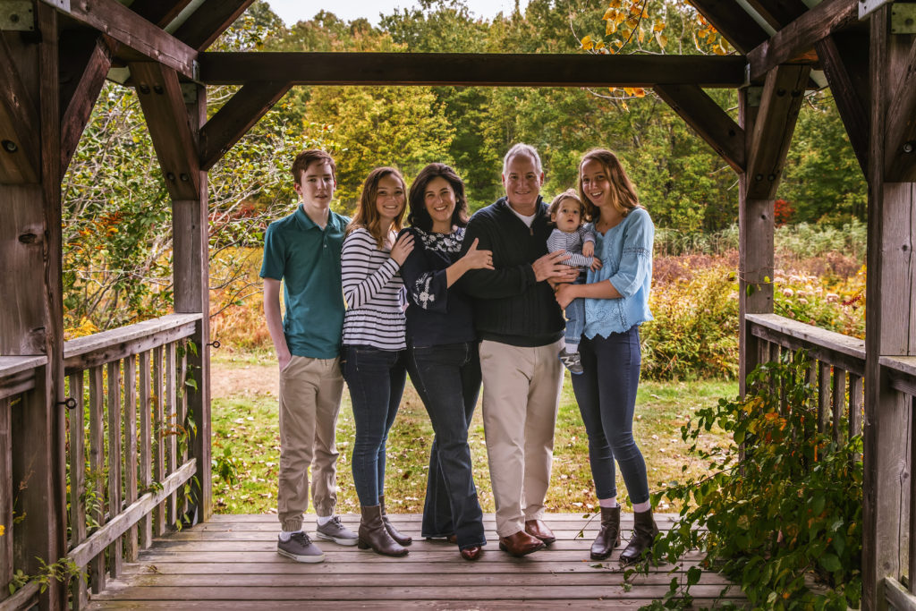 family of five posing on a bridge for a fall family photo session, Madison, CT photographer