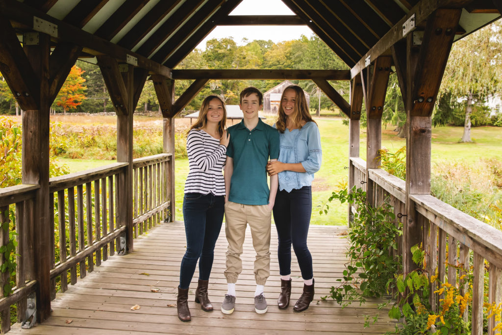 three siblings standing on a covered bridge, bauer park photography session