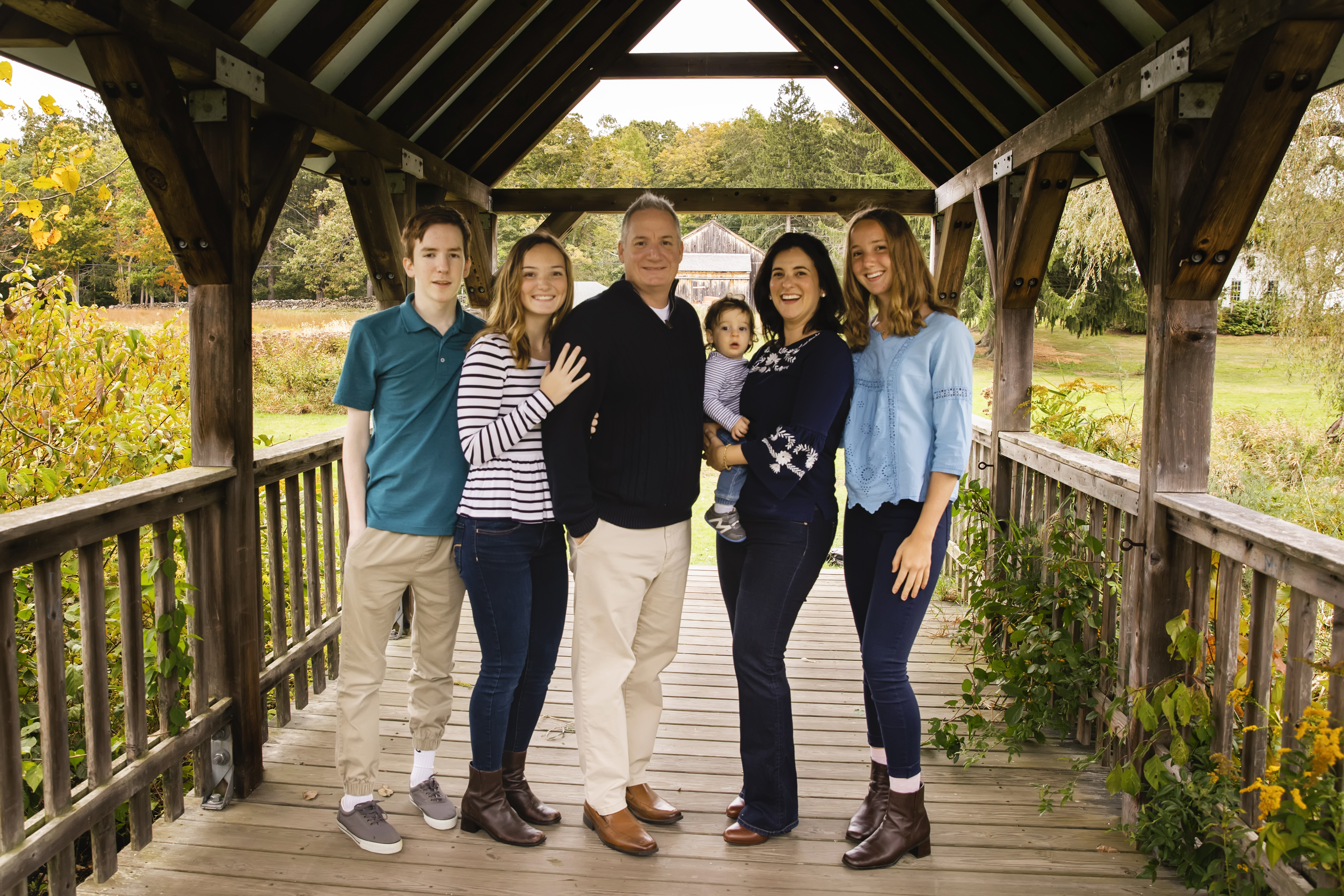 family of five posing on a bridge for a fall family photo session, Madison, CT photographer