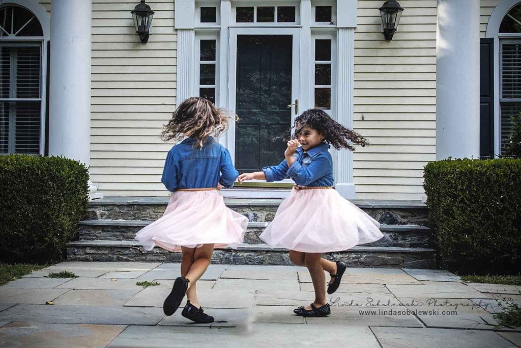 twin girls spinning around with pink tulle skirts, Connecticut Shoreline Family Photographer