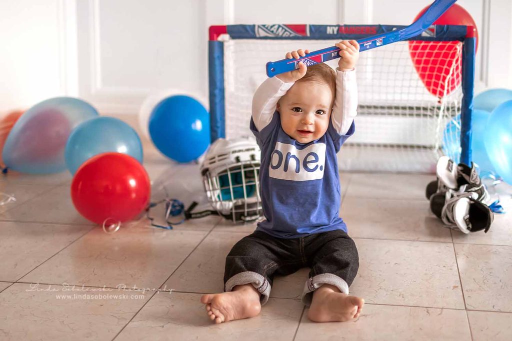 little boy in blue shirt holding a hockey stick, CT shoreline family photographer