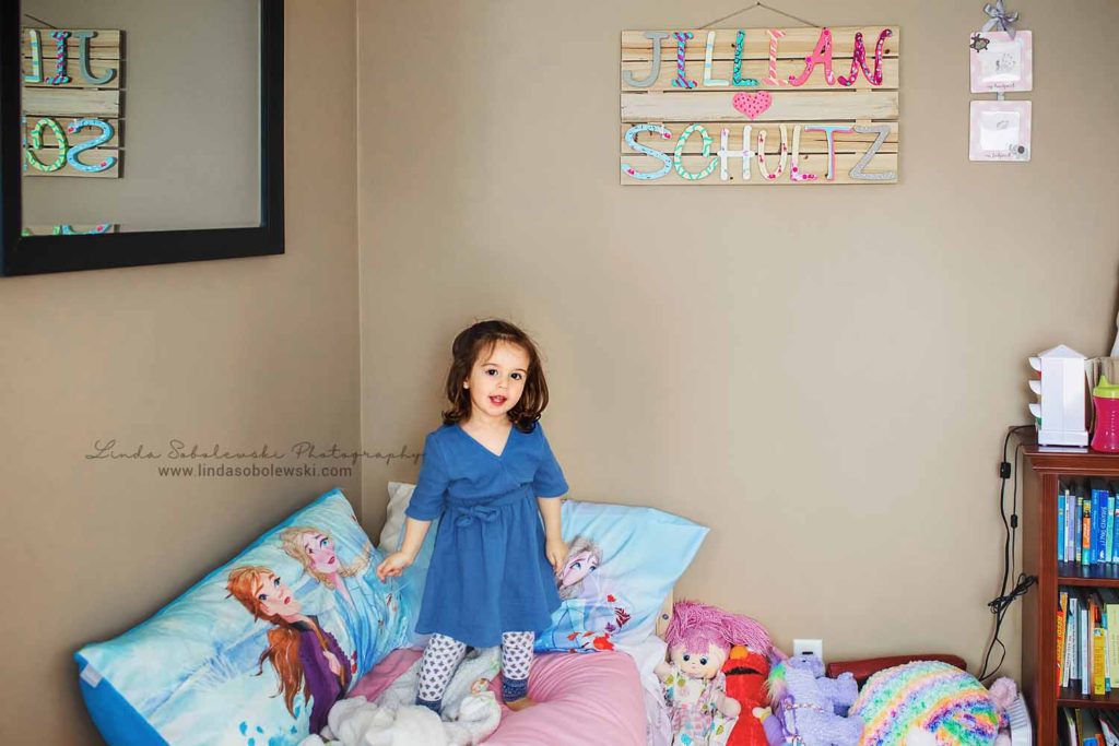 little girl in blue dress standing in her bedroom, Branford CT Newborn and Child photographer