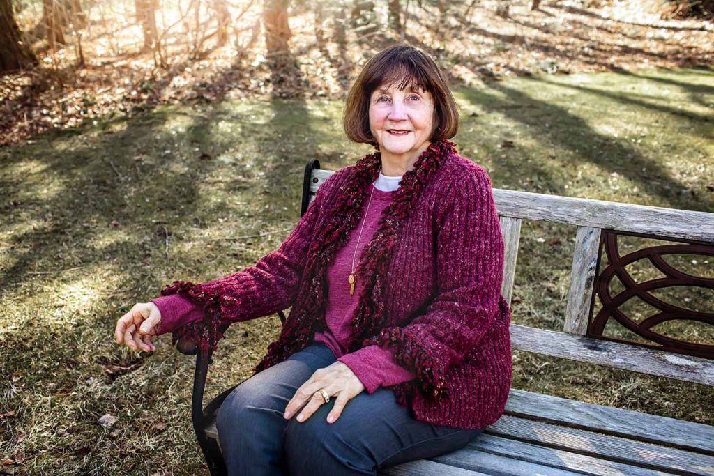woman with black hair and red sweater sitting on a bench, Connecticut Shoreline Family Photographer