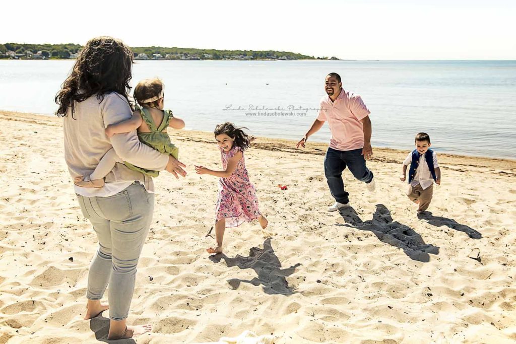 father and two children running to their mom on the beach, Family Photo Session at the Beach in Waterford Connecticut