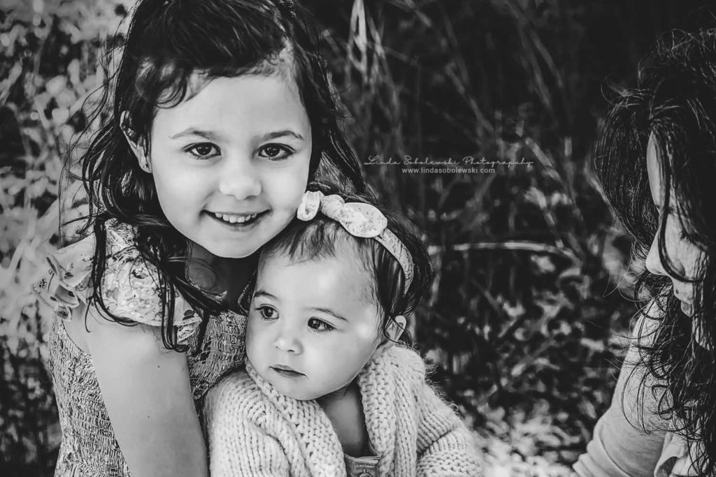 black and white image of a girl holding her baby sister, Old Saybrook Family and Child Photographer
