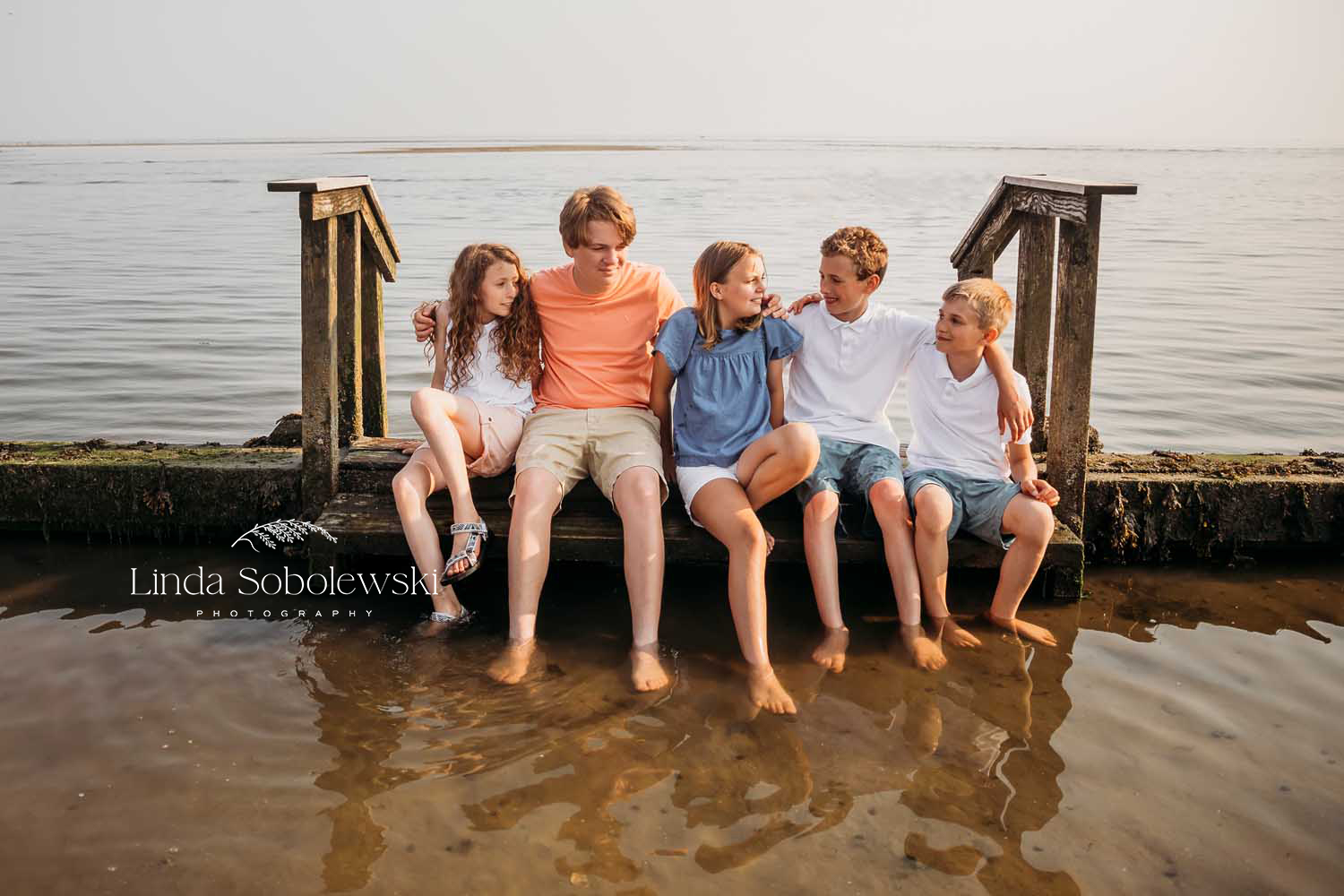 cousins sitting together at the beach, What is an extended family photo session with Old Saybrook CT Photographer