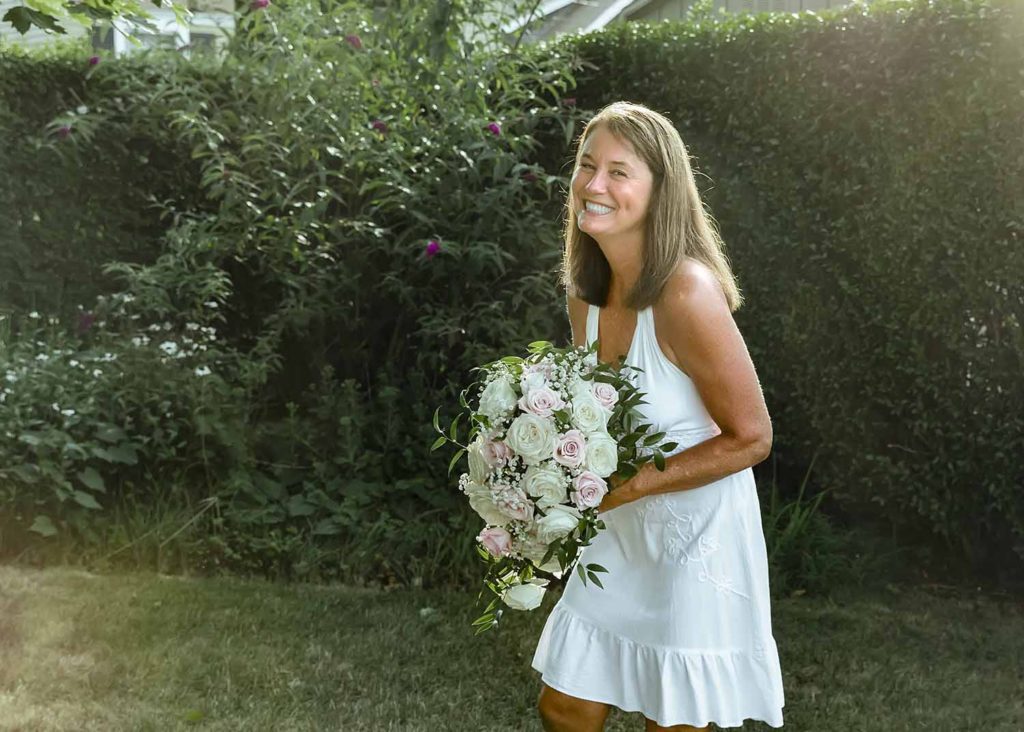 beautiful woman standing in the the sunlight with a bouquet of flowers, 30th anniversary celebration
