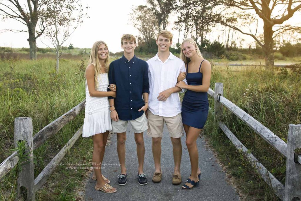 four young adults standing on a path, CT photographer family beach photoshoot