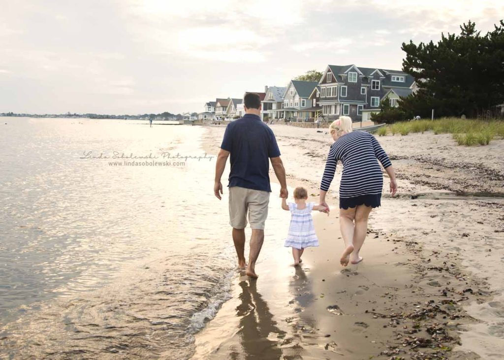 parent's holding their baby's hand at the beach, Old Saybrook Family and lifestyle photographer