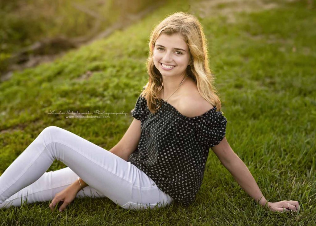 girl with blonde hair sitting on the grass, CT High School Senior Photographer
