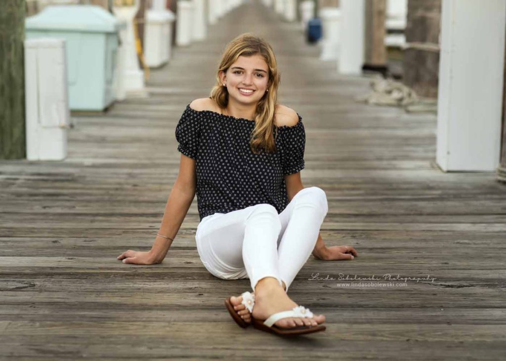 blonde girl with white jeans, sitting on a dock, CT High School Senior Photographer