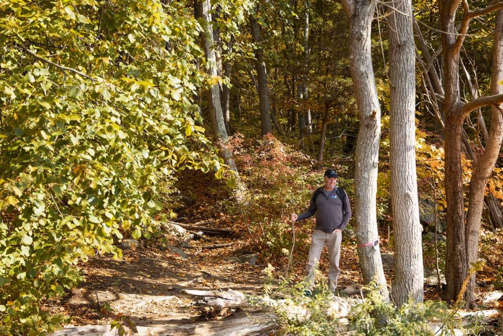 man standing in forest with colorfu leaves, CT Family photographer