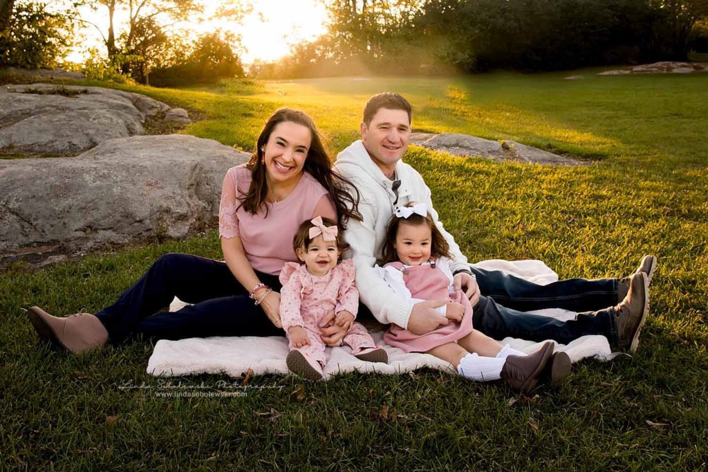 family of four sitting on the grass, Guilford CT Lifestyle Photographer