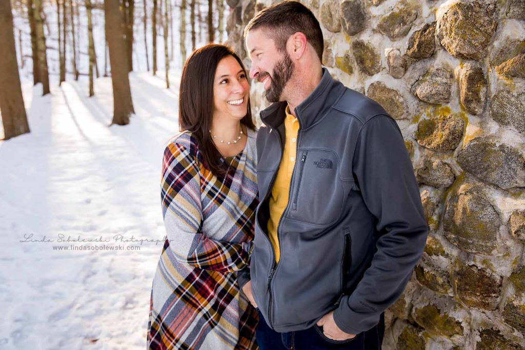 husband and wife with their arms around each other, Session in the Snow, CT Family Photographer