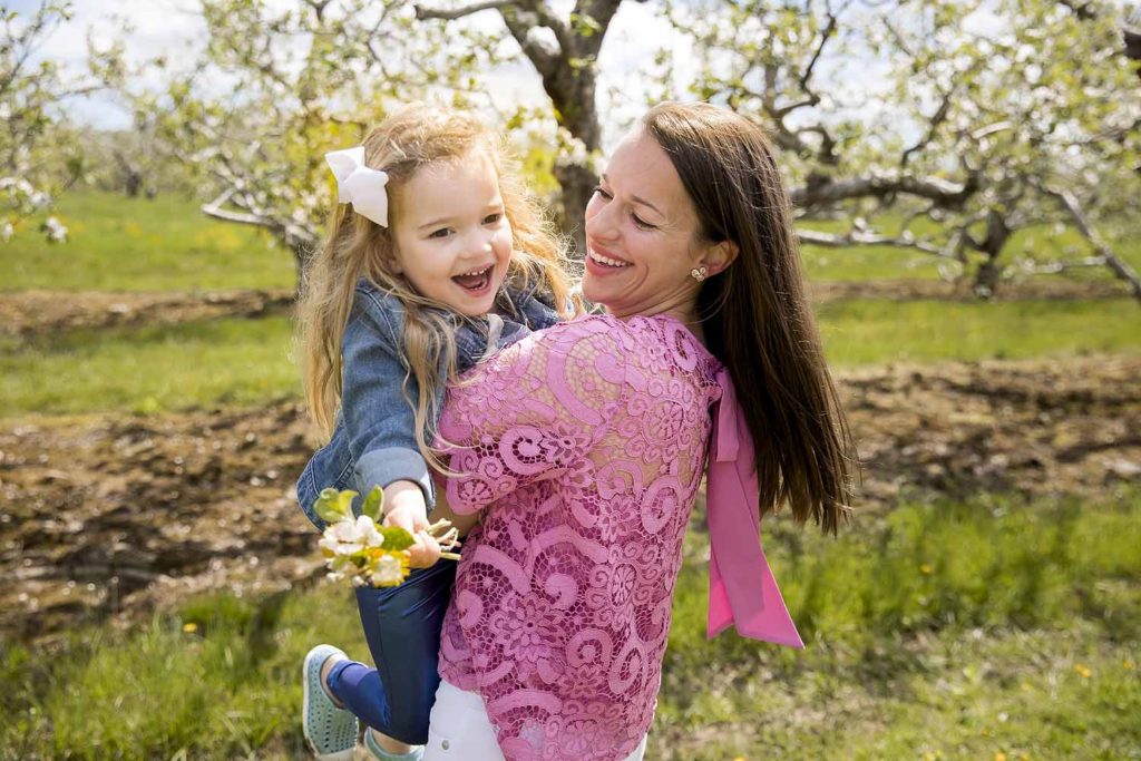 mom in pink top spinning her little girl around, posing tips for moms and her children, CT family photographer