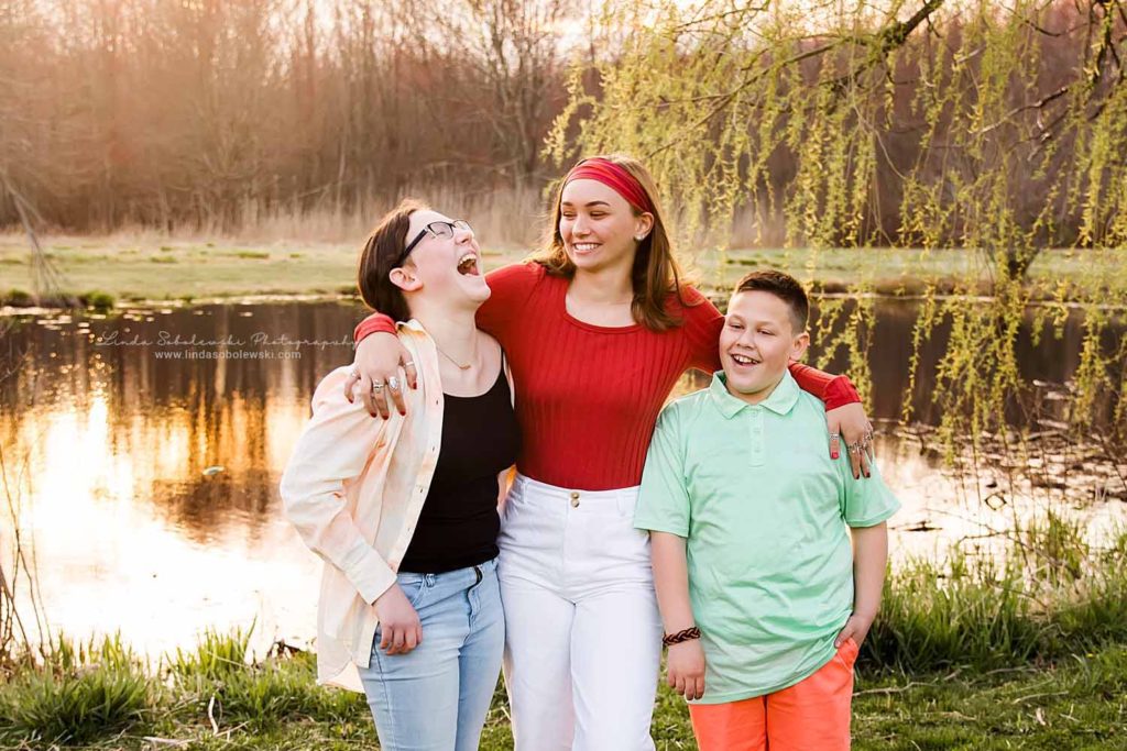 two sisters and their brother laughing, Bauer Park Family Session, CT Shoreline photographer