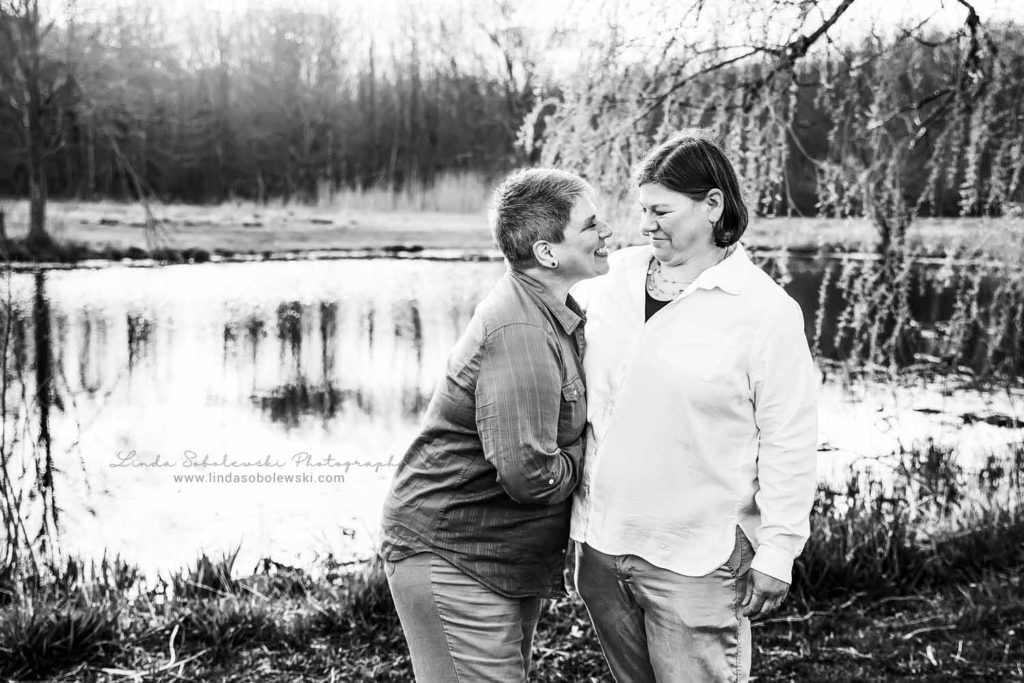 two women smiling at each other at a park, CT Family photographer