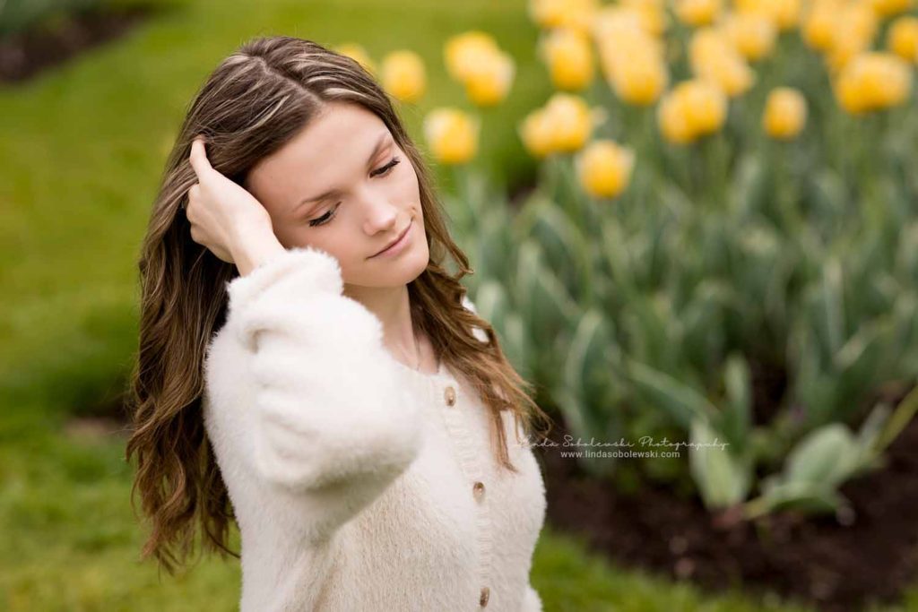 teenage girl in jeans standing in a tulip garden, Senior photo session at Elizabeth State Park, Madison, CT SeniorPhotographer