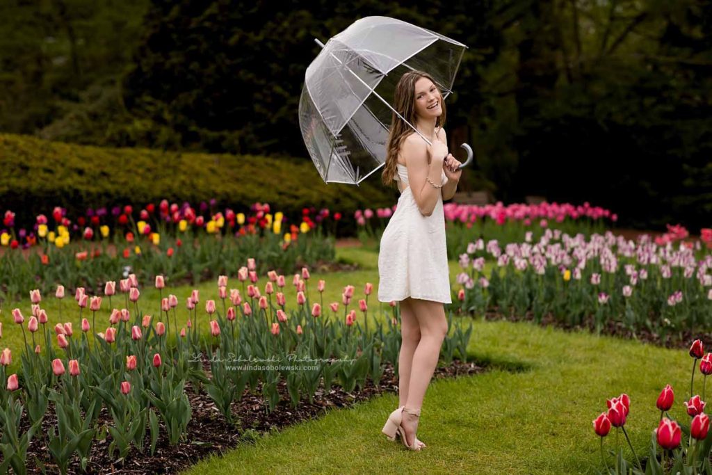 teenage girl in white dress standing in a tulip garden, Senior photo session at Elizabeth State Park, Westbrook, CT Photographer
