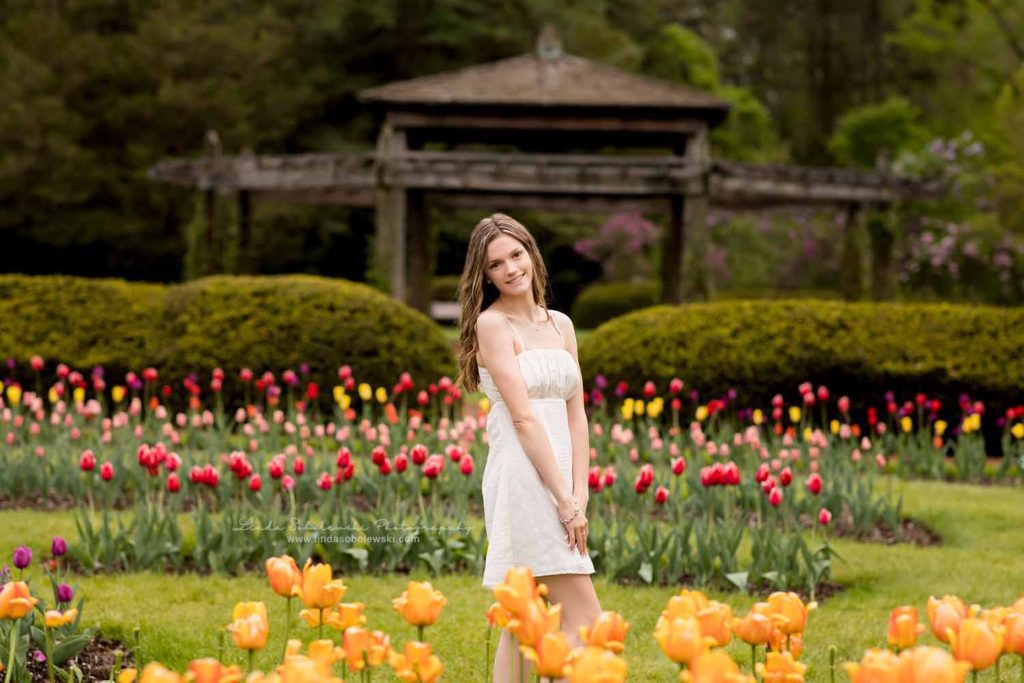 teenage girl in white dress standing in a tulip garden, Senior photo session at Elizabeth State Park, West Hartford, CT Photographer, 