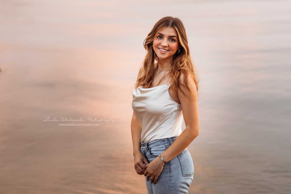 girl at the beach, with the sun setting behind her. CT high school senior photo shoot