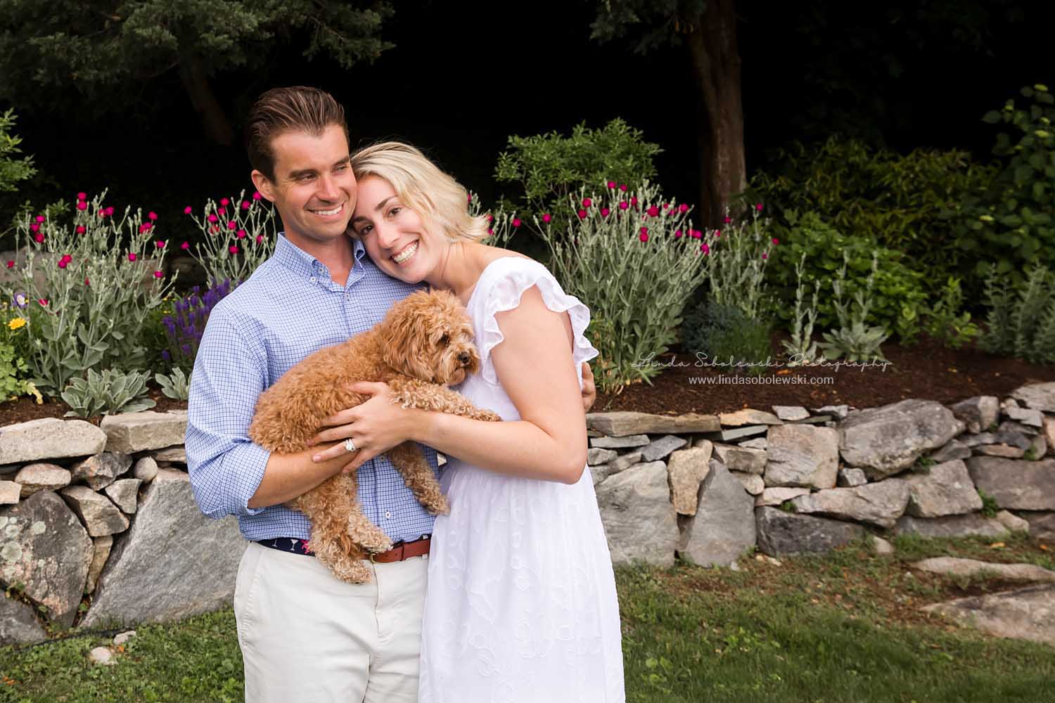 blonde couple holding their dog for a family photo session in Mystic, CT