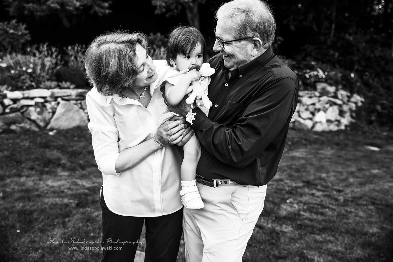 black and white image of grandparents holding their baby granddaughter, Family photo session, Mystic, CT photographer