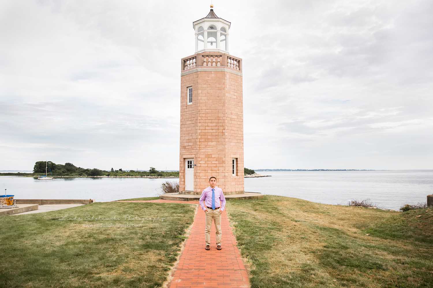 boy standing in front of a lighthouse, CT Senior Photographer